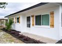 Exterior view of a well-maintained home with a white exterior, shuttered windows, and a nicely landscaped front yard at 4601 71St N Ave, Pinellas Park, FL 33781