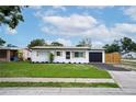 Well-maintained single-story home featuring a blacktop driveway, shuttered windows and a green lawn at 4601 71St N Ave, Pinellas Park, FL 33781