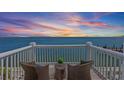 Outdoor balcony with wicker furniture overlooking panoramic ocean view at sunset at 4974 Coquina Key Se Dr, St Petersburg, FL 33705