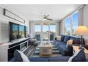 Cozy living room featuring water views, stylish furniture, a ceiling fan, and sliding glass doors to the balcony at 5701 Bahia Del Mar Cir # 408, St Petersburg, FL 33715