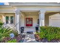 Inviting front porch featuring stately columns and an elegant red front door at 6324 Brevada Ln, Apollo Beach, FL 33572