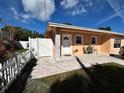 A cute single-story yellow home featuring a cozy porch and a white picket fence is shown at 8210 Marigold Ave, Tampa, FL 33614