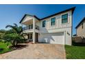 Attractive two-story home with a balcony, two-car garage, and a brick driveway at 8314 Capstone Ranch Dr, New Port Richey, FL 34655