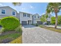 Townhome with gray brick paved driveway, neutral paint color, manicured landscaping and single-car garage at 1022 Orchard Arbour Ct, Tampa, FL 33613