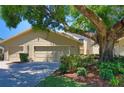 Charming home with a two-car garage, mature shade tree, and well-manicured lawn in a desirable neighborhood at 1093 Muirfield Ct, Tarpon Springs, FL 34688