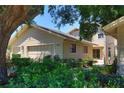 Exterior view of a charming home with well-maintained landscaping and a mature shade tree in the yard at 1093 Muirfield Ct, Tarpon Springs, FL 34688