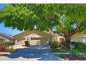 Charming home with a two-car garage, mature shade tree, and manicured lawn, offering inviting curb appeal at 1093 Muirfield Ct, Tarpon Springs, FL 34688