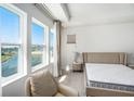 Bright bedroom with a view, featuring large windows, tray ceiling, and neutral color scheme at 1439 Gopher Loop, Tarpon Springs, FL 34689