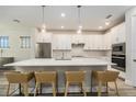 Modern kitchen with white cabinets, stainless steel appliances, quartz countertops, and pendant lighting at 1439 Gopher Loop, Tarpon Springs, FL 34689