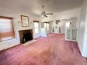 Spacious living room featuring a brick fireplace, bright windows, and carpeted flooring at 160 16Th Ne Ave, St Petersburg, FL 33704