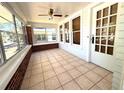 Enclosed front porch with tile flooring, offering ample natural light and a cozy seating area at 160 16Th Ne Ave, St Petersburg, FL 33704