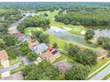 Beautiful aerial shot of a property in a serene, golf course community surrounded by mature trees and a lake at 17503 Edinburgh Dr, Tampa, FL 33647