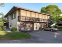 Two-story home with a balcony and three garage spaces, with a gold convertible parked in the driveway at 2934 Lichen Ln # D, Clearwater, FL 33760