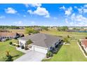 Aerial view of a home with a lush green lawn, scenic surroundings, and well-maintained landscaping at 303 Cranston Pl, Sun City Center, FL 33573