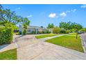 Quaint home with a well-maintained lawn, mature landscaping, and spacious driveway at 3310 W Swann Ave, Tampa, FL 33609