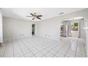 Open living area featuring tile flooring and a ceiling fan, connecting to the kitchen at 3310 W Swann Ave, Tampa, FL 33609