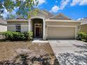 Inviting single-story home with a well-manicured lawn, tidy landscaping, and a two-car garage at 405 Laguna Mill Dr, Ruskin, FL 33570