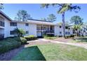 Condo building featuring a classic exterior design with lush green lawn and plants at 5019 Mill Pond Rd # 3128, Wesley Chapel, FL 33543