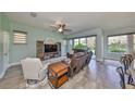 Inviting living room with tile flooring, modern ceiling fan, and sliding glass doors leading to the backyard at 6338 Springline Pl, Apollo Beach, FL 33572