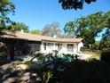 Inviting backyard featuring a sparkling pool, covered patio, and lush landscaping, perfect for outdoor entertaining at 908 N Knight St, Plant City, FL 33563