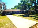 Lovely single-story house with a long driveway and verdant lawn framed by mature trees at 908 N Knight St, Plant City, FL 33563