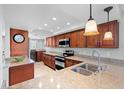 Well-lit kitchen with stainless steel sink and wooden cabinetry at 9433 Harbor Greens Way # 401, Seminole, FL 33776