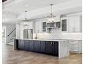 Modern kitchen features an island, white cabinets, stainless steel appliances, and pendant lights at 9514 Snapper Cir, Port Charlotte, FL 33981