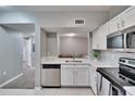 Modern kitchen with white cabinets, stainless steel appliances, and an open layout at 9526 Newdale Way # 101, Riverview, FL 33578