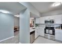 Bright kitchen with stainless steel appliances, white cabinetry, and a tiled backsplash at 9526 Newdale Way # 101, Riverview, FL 33578