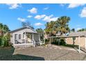 This home features a covered front porch, a carport, and gravel landscaping at 12404 Sunshine Ln, Treasure Island, FL 33706