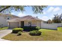 Beautifully landscaped front yard of a single-story home with a spacious driveway and attached two-car garage at 15616 Greyrock Dr, Spring Hill, FL 34610