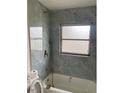 Upgraded bathroom showcasing stylish marble tiling, a modern shower head, and bathtub fixtures at 1606 Marilyn Ave, Bradenton, FL 34207