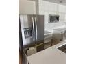 Modern kitchen with stainless steel refrigerator and microwave, complemented by white cabinetry and countertops at 1606 Marilyn Ave, Bradenton, FL 34207