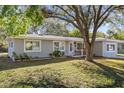Inviting single-story home with a lush front yard and mature trees, enhancing curb appeal at 1653 S Prescott Ave, Clearwater, FL 33756