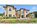 Beautiful Mediterranean-style home boasting a tile roof, arched windows, and meticulously maintained landscaping at 17005 Madres De Avila, Tampa, FL 33613