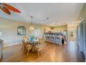 Open-concept dining area with a glass-top table, chairs, and chandelier next to kitchen at 19829 Gulf Blvd # 601, Indian Shores, FL 33785