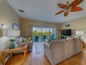 Cozy living room featuring comfortable couches, ceiling fan, and access to a balcony at 19829 Gulf Blvd # 601, Indian Shores, FL 33785