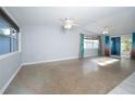 Bright living room featuring polished terrazzo floors, large windows, ceiling fans and sliding doors at 242 11Th Sw Ave, Largo, FL 33770