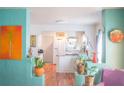 Open-concept living room flows into the kitchen with unique decor and vibrant turquoise walls at 2501 Emerson S Ave, St Petersburg, FL 33712