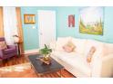 Bright living room with hardwood floors, white sofa with decorative pillows, and stylish art on the walls at 2501 Emerson S Ave, St Petersburg, FL 33712