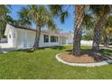 Exterior of home with landscaped yard, lush green lawn and palm tree accents at 2650 E Vina Del Mar Blvd, St Pete Beach, FL 33706