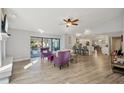 Open-concept living room with wood floors, a ceiling fan, and sliding glass doors that lead to the outdoor living space at 3994 Belmoor Dr, Palm Harbor, FL 34685