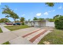 Street view of home showing carport, yard, and proximity to neighborhood at 5103 Town N Country Blvd, Tampa, FL 33615