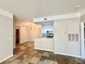 Open-concept living space with tile flooring, neutral walls, and a kitchen with white cabinets in the background at 17114 Carrington Park Dr # 207, Tampa, FL 33647