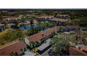 Aerial view of community buildings with mature trees, landscaping and a pond at 2537 Royal Pines Cir # 19I, Clearwater, FL 33763