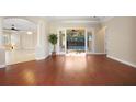 Open living room with hardwood floors and sliding glass doors that lead to the outdoor pool at 2685 Waters Edge Ct, Dunedin, FL 34698