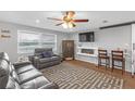 Cozy living room features a modern fireplace, ceiling fan, and wood-look flooring at 27103 Frampton Ave Ave, Brooksville, FL 34602