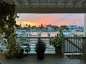 Picturesque view of the waterfront and boats at sunset from a covered outdoor porch with lush plants at 350 Pinellas Bayway S # 2, St Petersburg, FL 33715