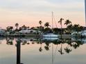Scenic waterfront view featuring a sailboat and palm trees reflected in calm waters at sunset at 350 Pinellas Bayway S # 2, St Petersburg, FL 33715