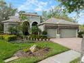 Attractive home featuring a three-car garage, stone detailing, and a landscaped front yard at 3633 Cordgrass Dr, Valrico, FL 33596